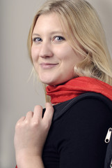 Beautiful young woman with red scarf looking over shoulder