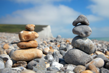 Fototapeta na wymiar Two stacks of pebble stones on beach