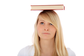 Frustrierte Studentin balanciert ein Buch auf dem Kopf