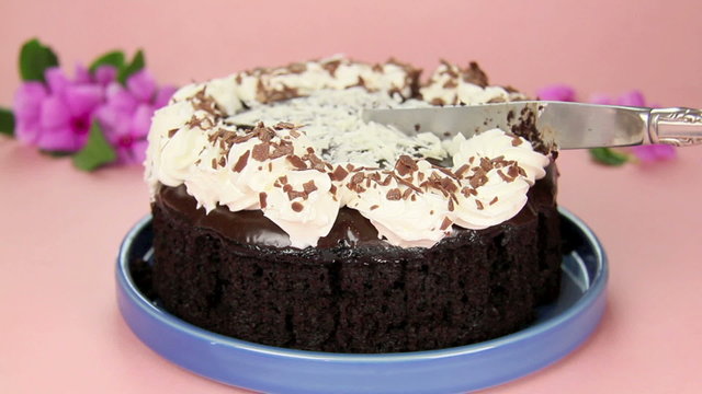 Shot of a slice being taken from a chocolate mud cake.