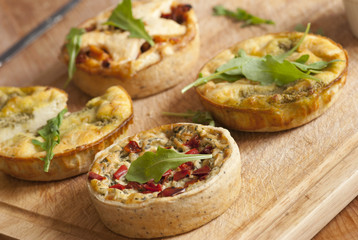 A selection of quiche on a wooden board