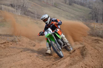 Fotobehang Motorsport Motocross rider with a strong slope turns sharply  © VVKSAM