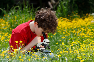 Boy using microscope outdoor