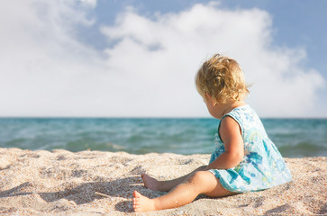 Fototapeta na wymiar young girl playing on sand beach