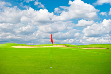 Obraz premium green golf field with cloudy sky background
