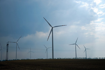 Wind turbines farm on sunset in summer