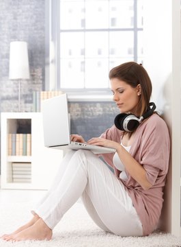 Portrait of woman using laptop at home