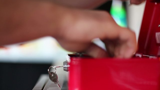 geld in rote geldkassette tun / putting money in a red cash box