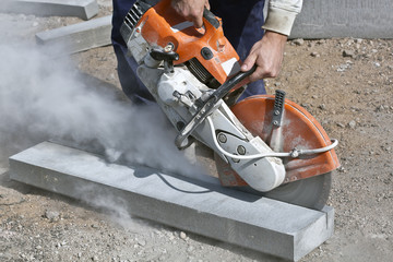 Construction worker cutting concrete curb - obrazy, fototapety, plakaty