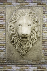 The lion head on the wall.