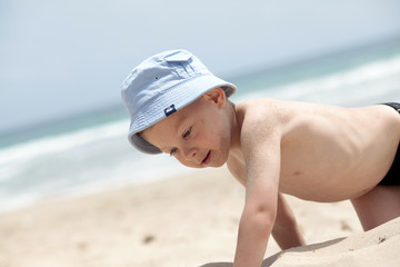Happy boy on tropical beach sand