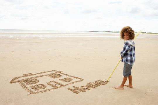 Boy Drawing In Sand