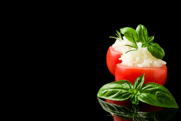 Pomodori ripieni di riso su sfondo nero