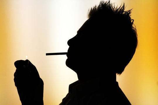 silhouette of smoking man on yellow green background