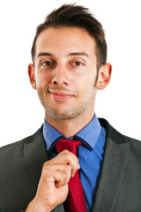 Smiling businessman adjusting his tie