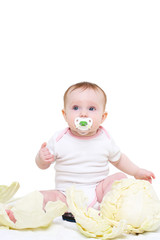 eight-monthly baby sits in cabbage leaves