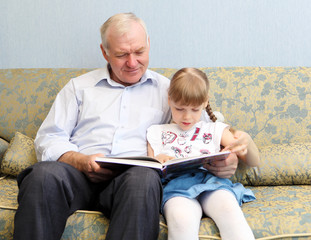 grandfather and granddaughter reading book