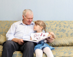 grandfather and granddaughter reading book