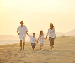 happy young family have fun on beach at sunset
