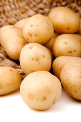Fresh potatoes in a basket, white background