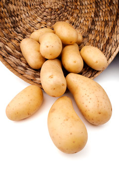 Fresh potatoes in a basket, white background