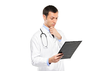 A portrait of a pensive medical doctor looking at clipboard