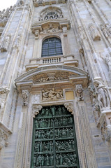 Door in the Gothic facade of the Cathdral in Milan Italy