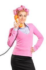 Young woman with hair rollers gossiping on a phone