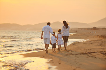 Fototapeta na wymiar szczęśliwa młoda rodzina zabawy na plaży o zachodzie słońca