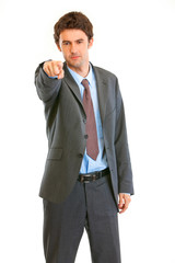 Serious modern businessman pointing finger at you