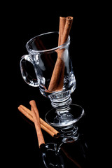 cinnamon sticks and cup an a black background