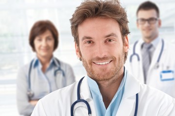 Fototapeta premium Portrait of doctor with colleagues behind