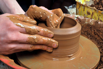 hands of a potter, creating an earthen jar on the circle