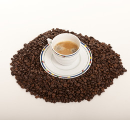 Coffe cup over coffee beans