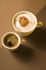 Two coffee cups with hot espresso and cappuccino