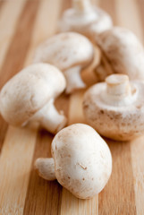 heap of tasty champignons on  a wooden brown board
