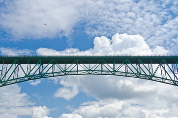 Fototapeta premium Bridge in the blue sky over white clouds