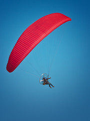 parapente paramoteur a voile rouge  dans le ciel bleu