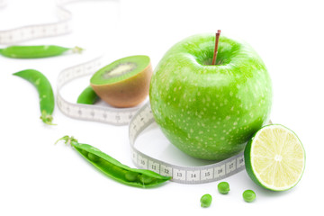 apple,lime,peas,kiwi and measure tape isolated on white