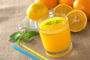 Freshly squeezed orange juice with orange slice, mint leaf