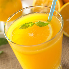 Freshly squeezed orange juice with orange slice, mint leaf