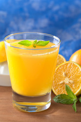 Freshly squeezed orange juice with orange slice, mint leaf