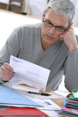 Particulier penché sur les  factures et charges