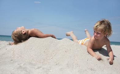 two children playing on sand beach