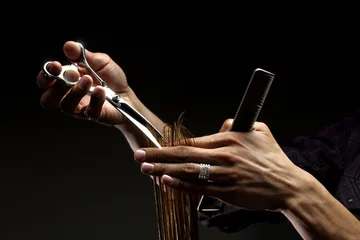 Papier Peint photo Lavable Salon de coiffure Un gros plan des mains du coiffeur coupant les cheveux
