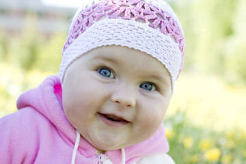 Smiling baby against dandelion field