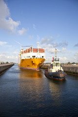 Container ship with tug boat in lock