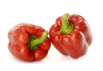 Two wet red peppers isolated on white