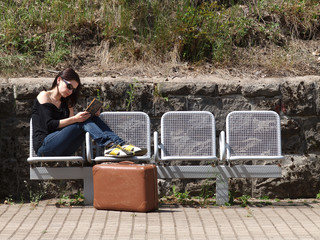 Sitzen am Bahnsteig mit Buch