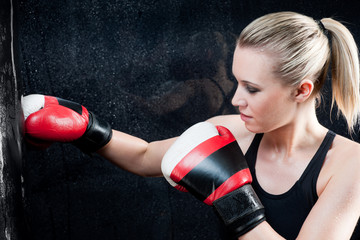 Boxing training woman in gym punching bag